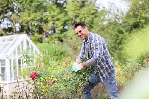 Worker wearing full PPE while pruning hedges